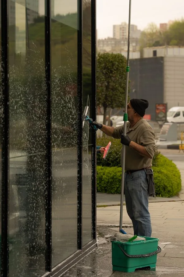 Laveur de vitres professionnel devant une vitrine
